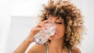 Femme buvant un verre d'eau pure