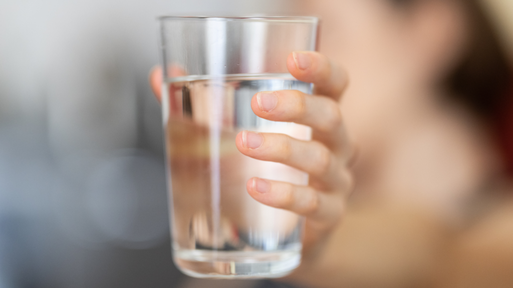 femme qui tend son verre d'eau